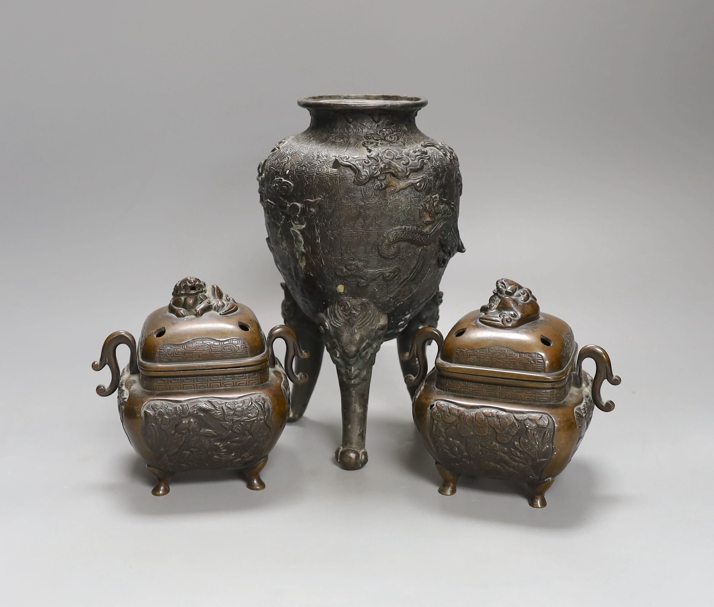 A pair of Japanese bronze censers and covers and a Japanese bronze tripod censer, 23cm tall, (3)